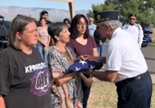 Presenting folded flag to family of deceased veteran.