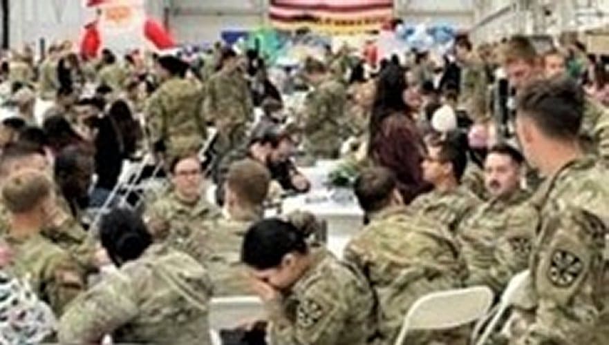 Panoramic view of Army National Guard and family members at annual Christmas event.