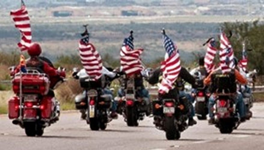 American Legion Post 132 Motorcycle Riders formation displaying United States Flags.