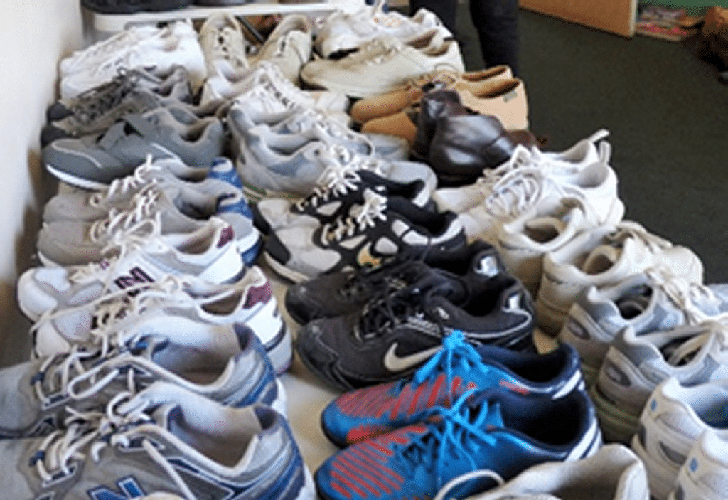 Table full of donated shoes for homeless and at-risk veterans.