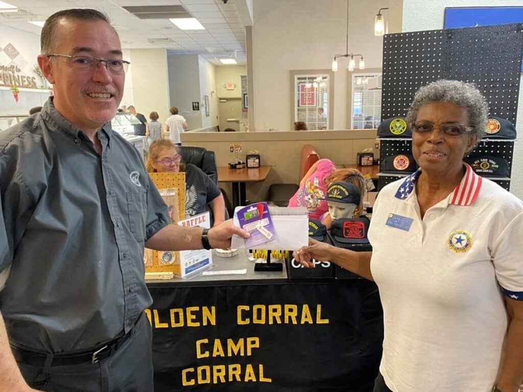 Golden Corral manager accepting donation check from Auxiliary Unit 132 member Onita Davis.