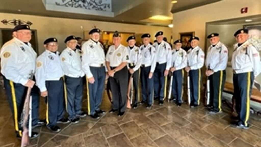 Twelve members of American Legion Post 132's Color Guard team in full uniform, white shirts, dark blue pants and beret.