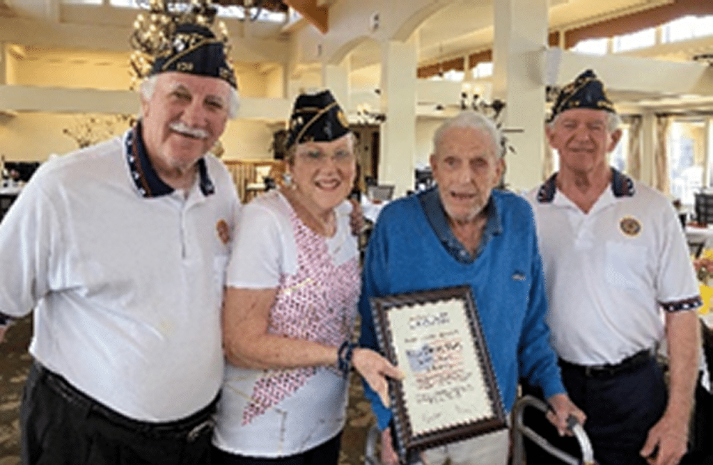 Three American Legion members presenting certificate to WWII veteran.