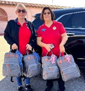 Two members of American Legion Auxiliary Unit 132 with backpacks filled with baby care items for new mothers at the Tucson VA Womens' Center.