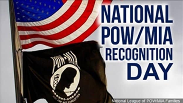 National POW/MIA recognition day banner with United States and POW/MIA flags on a pole, curled by wind.