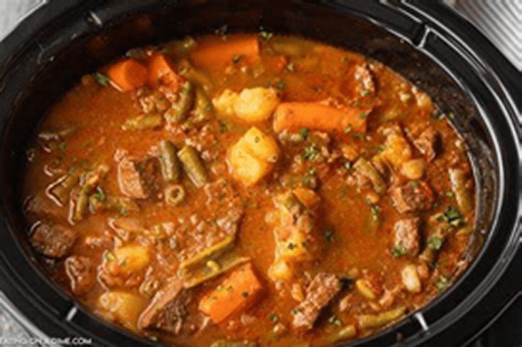 Beef stew in a large black pot.