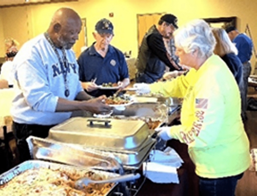 Auxiliary Unit members serving dinner to attendees.